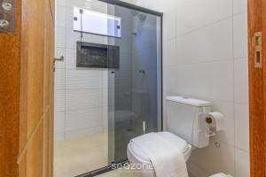 a bathroom with a toilet and a glass shower at Aconchegante apartamento bem mobiliado PDM005 in Porto Seguro