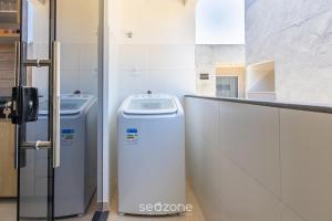 a bathroom with two trash cans next to a counter at Aconchegante apartamento bem mobiliado PDM005 in Porto Seguro