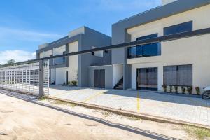 a modern house with a car parked in front of it at Aconchegante apartamento bem mobiliado PDM005 in Porto Seguro