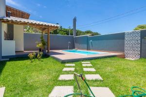 a backyard with a swimming pool and a fence at Aconchegante apartamento bem mobiliado PDM005 in Porto Seguro