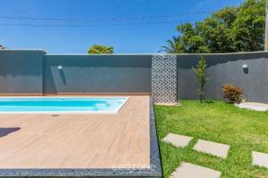 a backyard with a swimming pool and a fence at Aconchegante apartamento bem mobiliado PDM005 in Porto Seguro