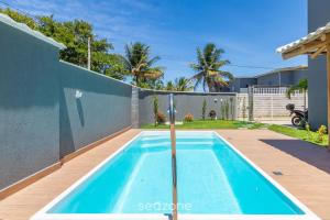 a swimming pool in the backyard of a house at Aconchegante apartamento bem mobiliado PDM005 in Porto Seguro