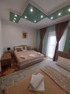 a bedroom with two beds and a green ceiling at Becic Apartments in Ulcinj