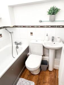 a white bathroom with a toilet and a sink at Modern Apartment, Nottingham City Centre, With Parking! Sleeps 4 in Nottingham