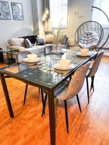 a glass table and chairs in a living room at Modern Apartment, Nottingham City Centre, With Parking! Sleeps 4 in Nottingham