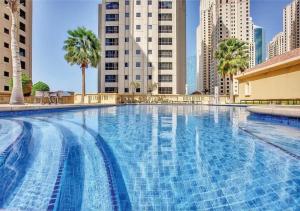a large swimming pool in a city with tall buildings at Spacious Studio in Murjan 2: Near the Beach in Dubai
