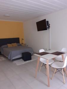 a bedroom with a bed and a table and chairs at Departamento El Olivo con cochera in Santa Rosa