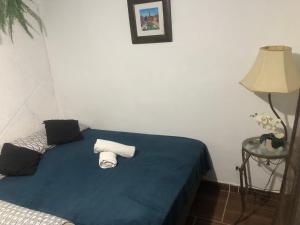 Un dormitorio con una cama azul con toallas. en Apartamento aconchegante com deck, en Río de Janeiro