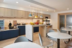 a kitchen and dining room with tables and chairs at TownePlace Suites Dulles Airport in Sterling