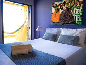 Pousada Beija Flor في سلفادور: غرفة نوم بسرير كبير عليها لوحة على الحائط