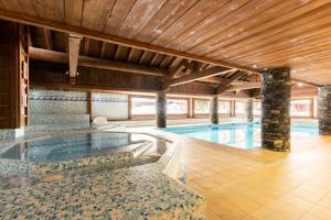 een groot zwembad met een zwembad bij Résidence Les Fermes du Soleil - maeva Home - Appartement 4 pièces 7 person 93 in Les Carroz d'Araches
