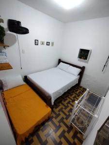 Habitación pequeña con 2 camas y lámpara en Espaço Completo Privativo - Aconchego Olinda Alta, en Olinda