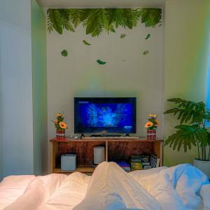 a bedroom with a tv on a table with a bed at Azure Staycation Suites by MECS in Manila