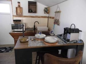 a kitchen with a table with plates on it at L'histoire de l'ouest , jacuzzi appartement in Dole