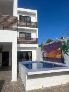 a building with a swimming pool on the side of it at ALMAR FAMILY HOUSE in Holbox Island