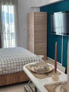 ein Schlafzimmer mit einem Bett und einem Tisch mit einer Kerze in der Unterkunft Central Square Studio in Xánthi