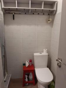 La salle de bains est pourvue de toilettes et d'un tabouret rouge. dans l'établissement Viviers du lac centre, à Viviers-du-Lac