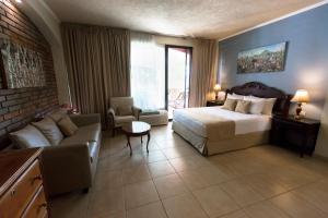 Habitación de hotel con cama y sofá en Los Altos Apartments & Studios en Managua