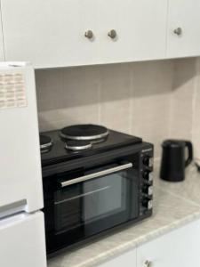 eine schwarze Mikrowelle in der Küche in der Unterkunft Central Square Studio in Xánthi