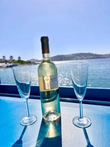 a bottle of wine and two glasses on a table at mills suites mykonos in Mýkonos City