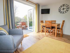 a living room with a couch and a table and chairs at Little Oaklands in Lostwithiel