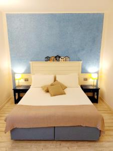 a bedroom with a large white bed with two lamps at Hotel La Villa Del Mare in Cagliari