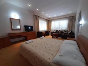 a bedroom with a large bed and a living room at Vila Doru Predeal in Predeal