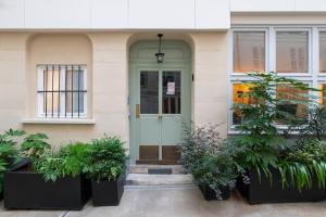 una puerta delantera de un edificio con macetas en Bright & Stylish 1BD FlatFolies BergèreHaussmann, en París