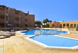 a large swimming pool in front of a building at La Tejita in La Tejita