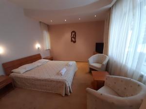 a hotel room with a bed and two chairs at Vila Doru Predeal in Predeal