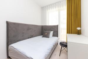una camera da letto con letto con testiera grigia e finestra di Papli Luxury Beach Residence a Pärnu