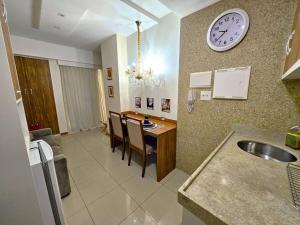a kitchen with a table and a clock on the wall at Lindo e decorado, Hotel Vista in Brasília