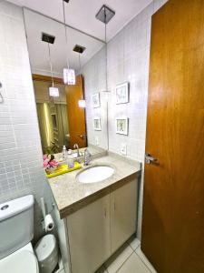 a bathroom with a sink and a toilet and a mirror at Lindo e decorado, Hotel Vista in Brasilia