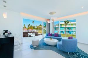 sala de estar con sillas azules y mesa en Sunrise Miches Beach Resort, Punta Cana - All Inclusive - Adults Only, en Punta Cana