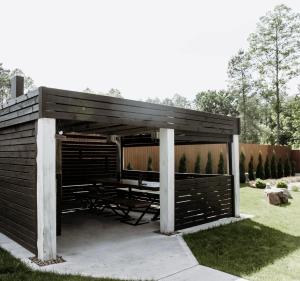 a wooden shed with a picnic table in the grass at Royal Relax in Khorodelets