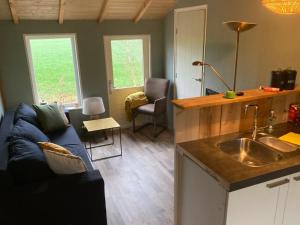 cocina y sala de estar con sofá azul en 't Zaandhuus, en Stuifzand