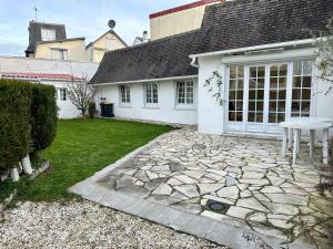 Cette maison blanche dispose d'une table et d'une terrasse. dans l'établissement RELAX HOME Maison et studio ensemble, à Deauville