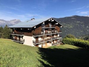 a building on a hill with mountains in the background at Résidence Amethyste - 2 Pièces pour 4 Personnes 334 in Saint-Gervais-les-Bains