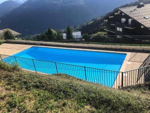 a large blue swimming pool next to a house at Résidence Amethyste - 2 Pièces pour 4 Personnes 334 in Saint-Gervais-les-Bains