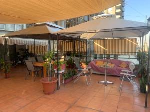 un patio con sombrilla, mesas y sillas en Terraza Santa Lucia,Suites "Como en su Casa", en Santiago