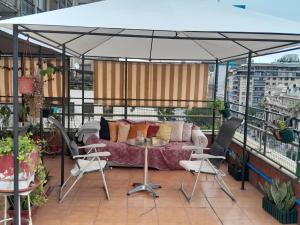 eine Terrasse mit einem Sofa und Stühlen auf dem Balkon in der Unterkunft Terraza Santa Lucia,Suites "Como en su Casa" in Santiago