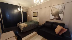 a living room with a bed and a couch at Unidade Ravena - Centro in Ribeirão Preto
