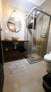 a bathroom with a glass shower and a sink at Unidade Ravena - Centro in Ribeirão Preto