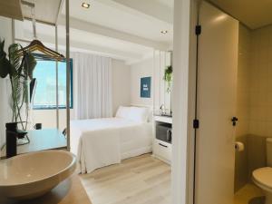 a bathroom with a bedroom with a bed and a sink at Apê Pátio Paulista in São Paulo +37 photos