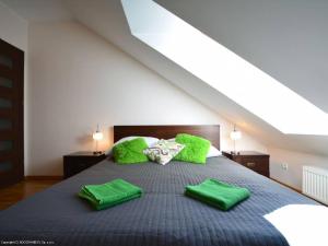 a bedroom with a bed with green blankets and pillows at Apartament Pod Giewontem in Zakopane +13 photos