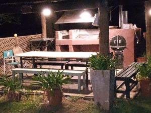 una mesa y bancos en un patio por la noche en Hotel Posada El Recodo en Villa del Totoral