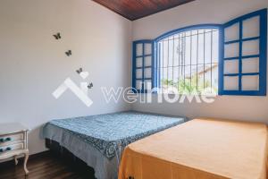 een slaapkamer met een bed en een raam bij Casa a 10 min da Praia do Forte, em Cabo Frio in Cabo Frio