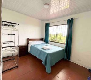 a small bedroom with a bed and a window at Finca La Luna - Bed & Breakfast on an organic farm in Concepción