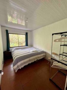 1 dormitorio con 1 cama en una habitación con ventana en Finca La Luna - Bed & Breakfast on an organic farm, en Concepción