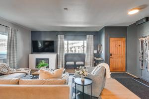 a living room with a couch and a table at Downtown Winter Park Condo with Free Bus to Ski Base in Winter Park